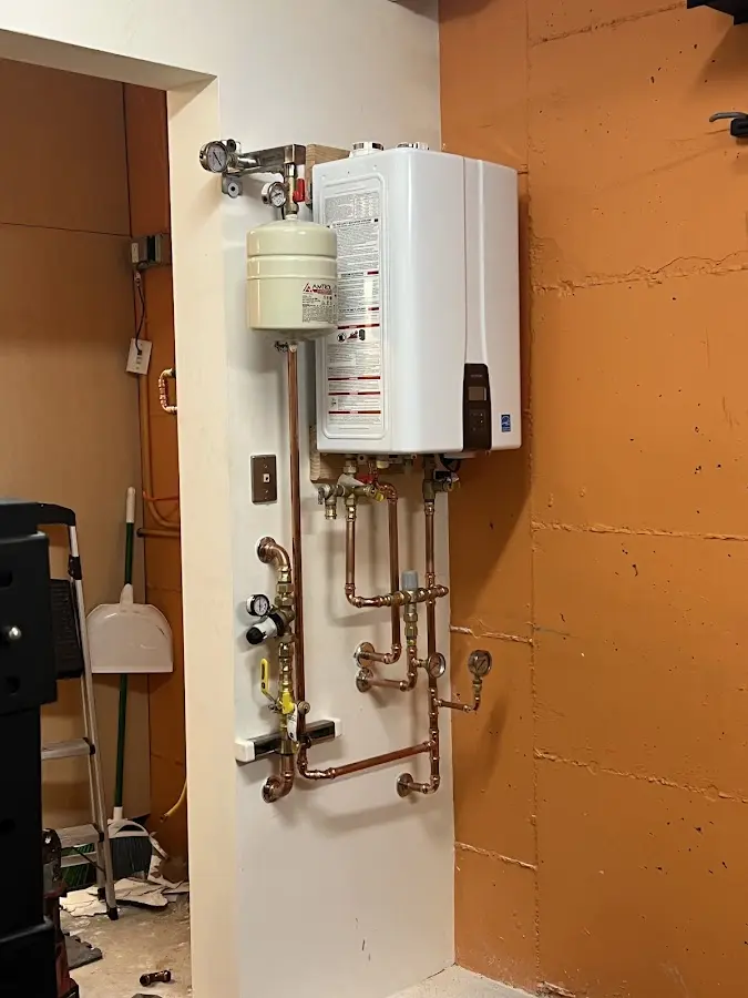 Plumbing technician inspecting water heater connections in Jerome